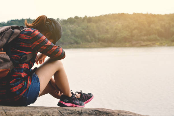 istock Young Woman Sitting On Rock By Lake 767993047