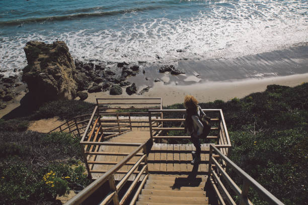 istock High Angle View Of Woman Standing On Staircase By Beach 768014567