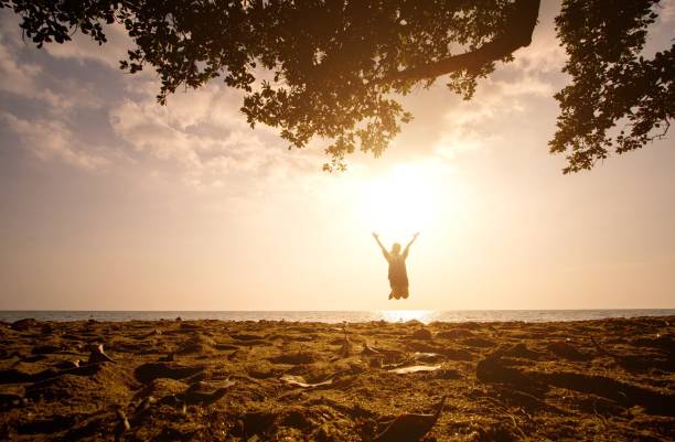 istock Woman Jumping On Beach Against Sky During Sunset 769774789