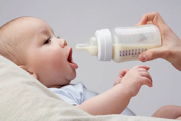 Photo of A baby being fed a bottle