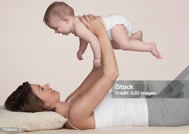 A Woman Holding A Baby Stock Photo - Download Image Now - Diaper, Colored Background, Mother