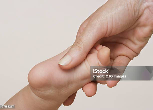 Weibliche Hand Hält Ein Babys Foot Stockfoto und mehr Bilder von 30-34 Jahre - 30-34 Jahre, 6-11 Monate, Anfang