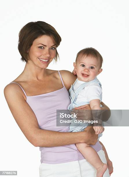Una Mujer Sostiene Un Bebé Foto de stock y más banco de imágenes de Fondo blanco - Fondo blanco, Madre, 30-34 años