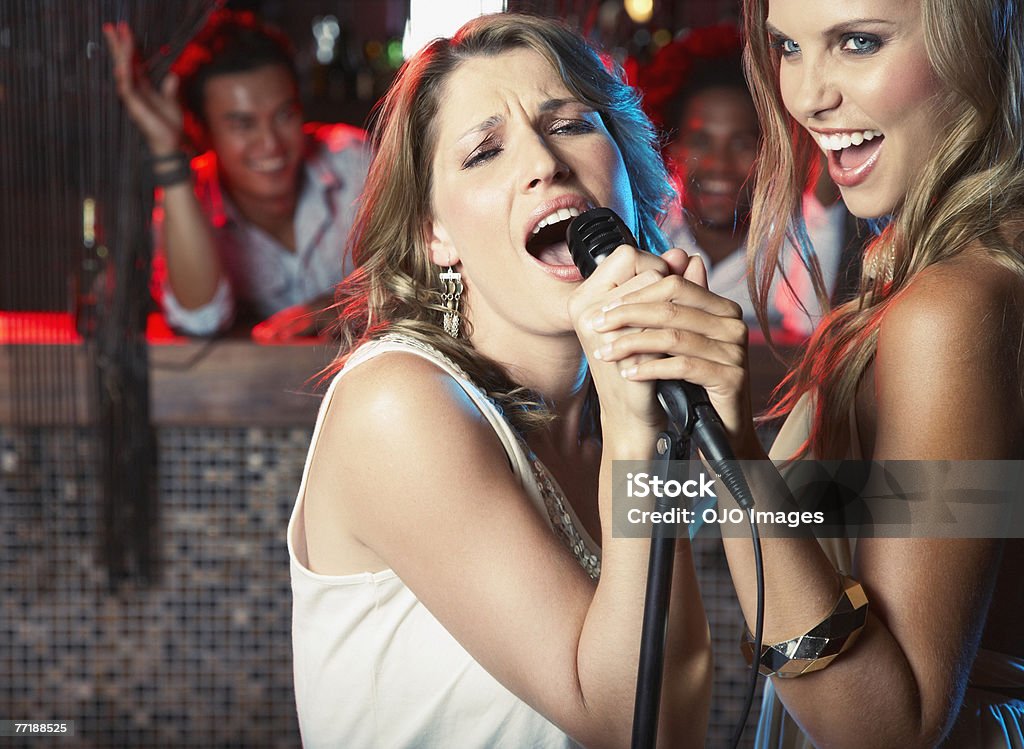 Friends hanging out en un club de música - Foto de stock de Karaoke libre de derechos