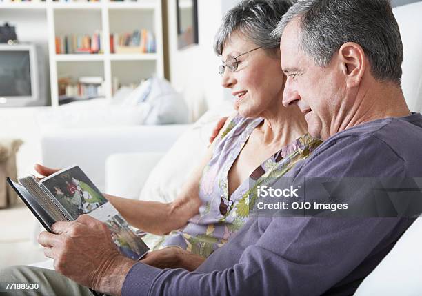 A Couple Looking At Pictures Stock Photo - Download Image Now - Photo Album, Photography, Senior Couple