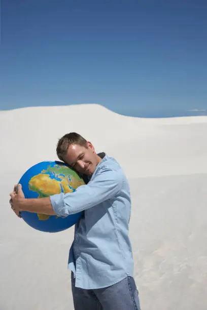 Photo of A man hugging a globe