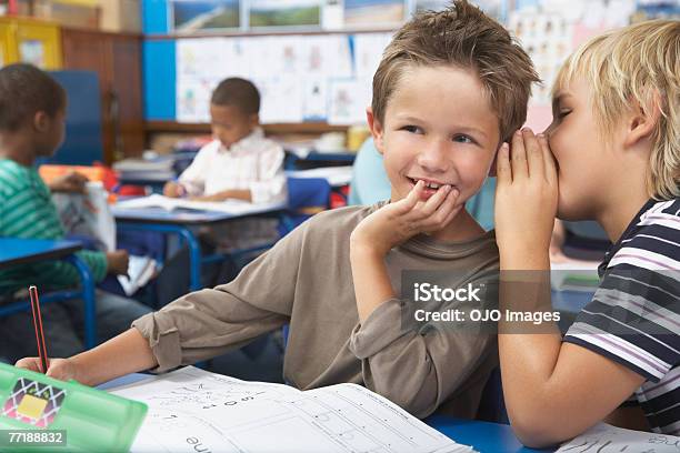 Students In Class Whispering Stock Photo - Download Image Now - Whispering, Classroom, Mischief