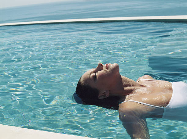 uma mulher relaxante na água - flutuar na água - fotografias e filmes do acervo