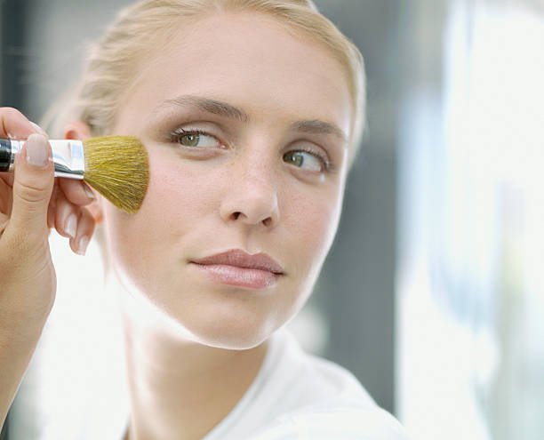 uma mulher aplicando maquiagem - make up cosmetics make up brush beauty - fotografias e filmes do acervo