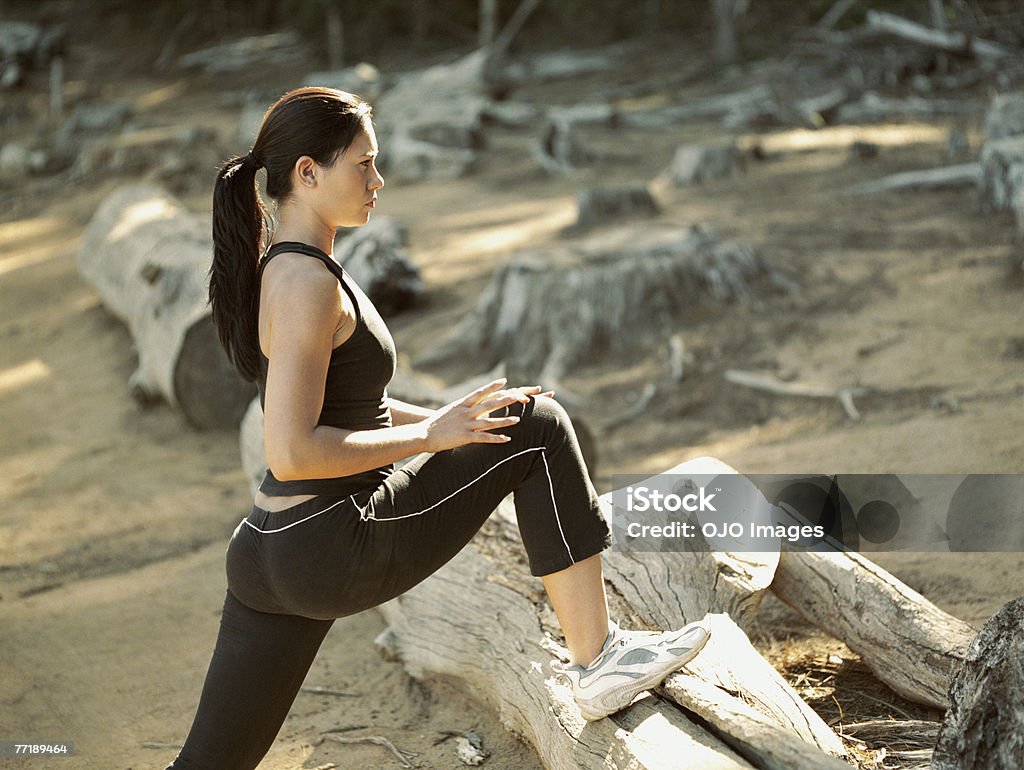 Mujer estiramiento sus piernas en el bosque - Foto de stock de 20-24 años libre de derechos