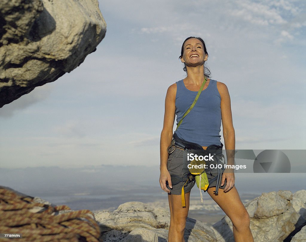 Uma mulher alpinista no topo de uma montanha - Foto de stock de Montanhismo royalty-free