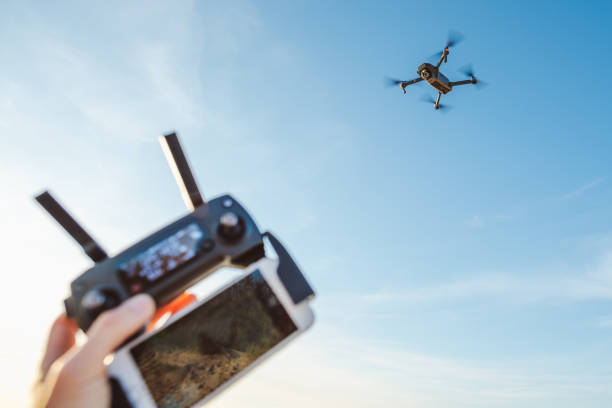 istock Cropped Hand Of Person Operating Drone Against Sky 773128017