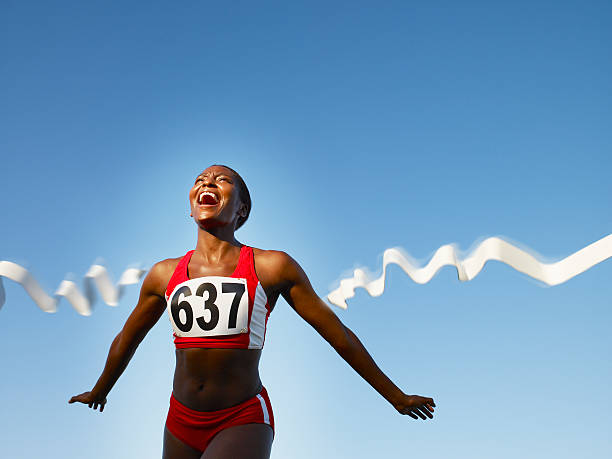 racer crossing the finish line smiling - athletes ภาพสต็อก ภาพถ่ายและรูปภาพปลอดค่าลิขสิทธิ์