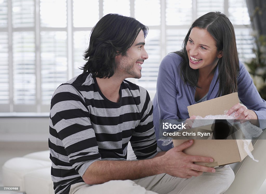 Souriant Couple ouvrir une boîte - Photo de 25-29 ans libre de droits