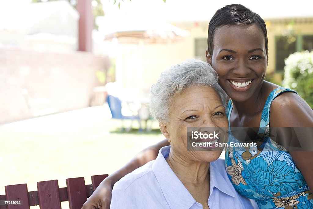 Two women outdoors on wooden bench  Daughter Stock Photo