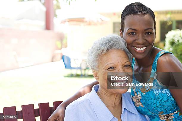 Two Women Outdoors On Wooden Bench Stock Photo - Download Image Now - Daughter, African-American Ethnicity, Care