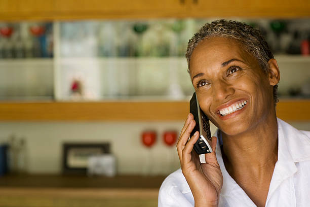 Woman on cordless telephone smiling  cordless phone stock pictures, royalty-free photos & images