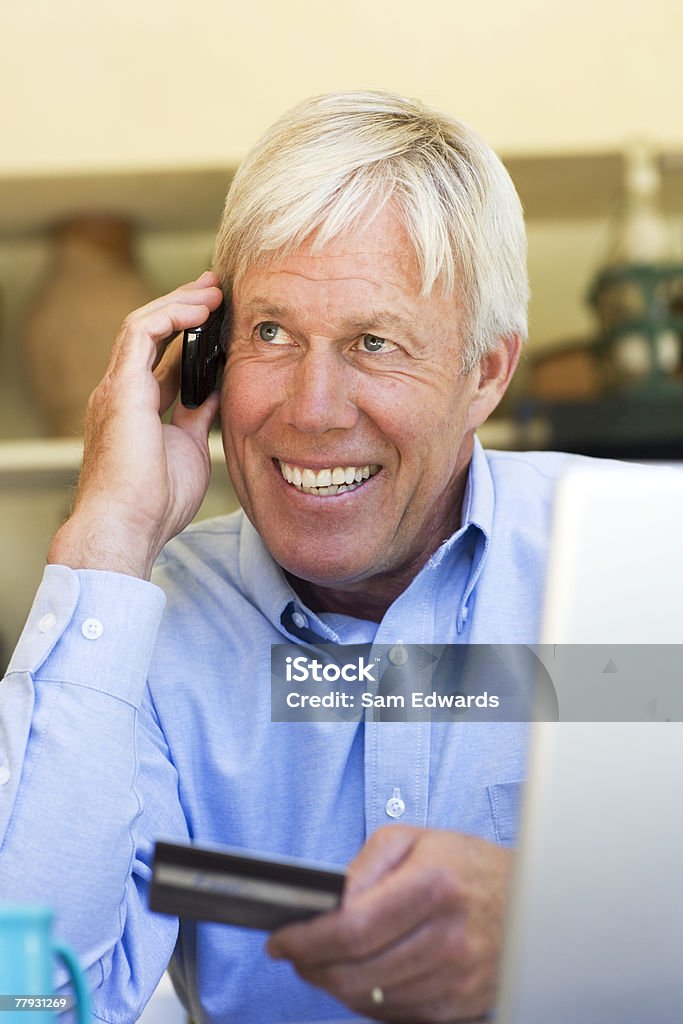 Człowiek za pomocą karty kredytowej na zakupy na telefon - Zbiór zdjęć royalty-free (60-64 lata)