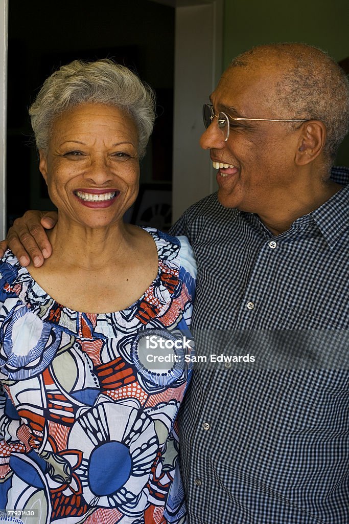 Couple embracing in doorway smiling  African Ethnicity Stock Photo
