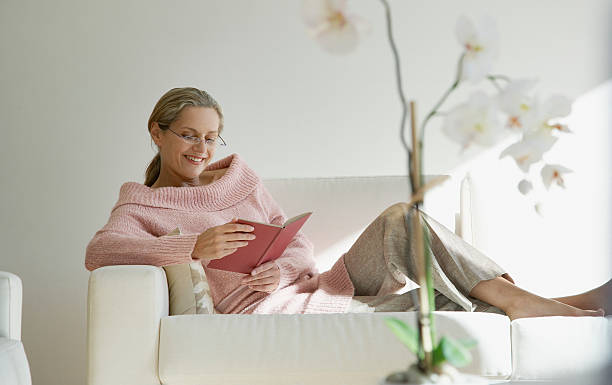 mujer leyendo una flor - women book mature adult reading fotografías e imágenes de stock