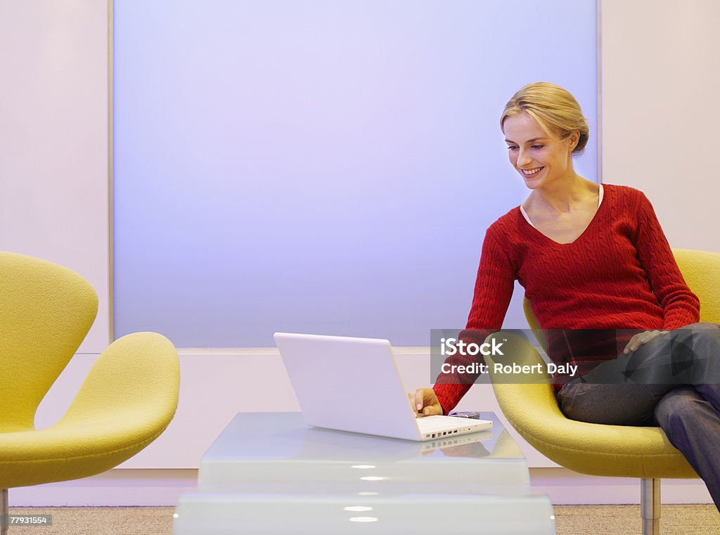 女性の椅子に座って、ラップトップ - オフィスのロイヤリティフリーストックフォト