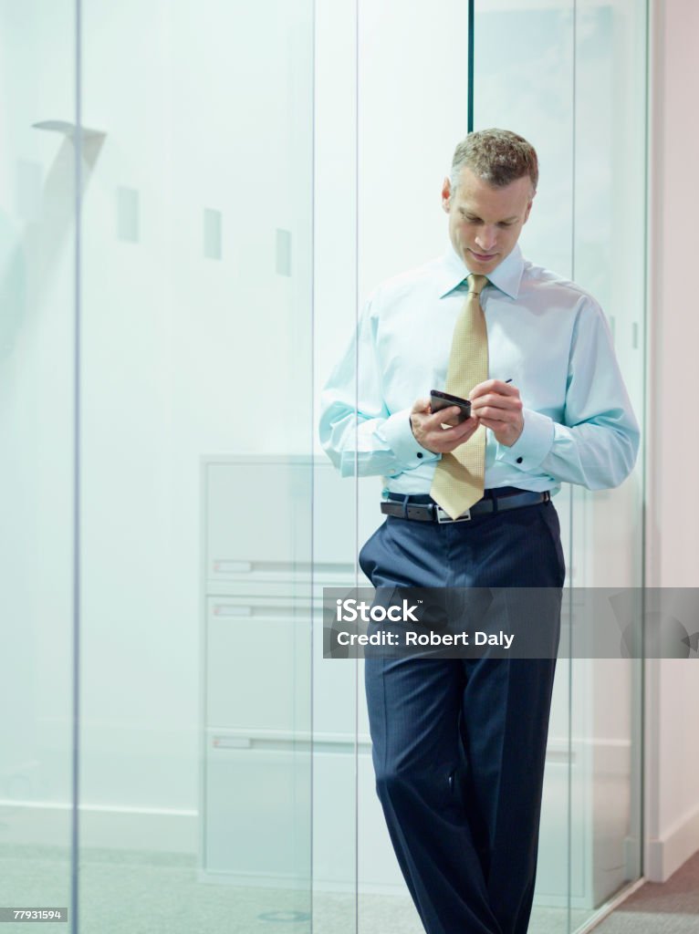 Businessman with PDA in office hallway  40-44 Years Stock Photo