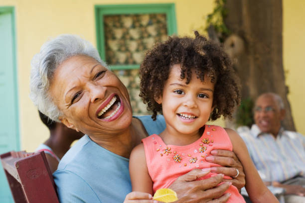 Woman and young girl outdoors with people in background  Grandchild stock pictures, royalty-free photos & images