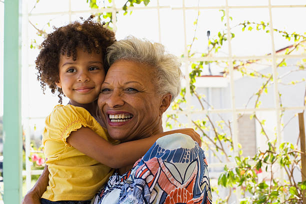 mujer y joven chica acogedor al aire libre - grandparent adult smiling looking at camera fotografías e imágenes de stock