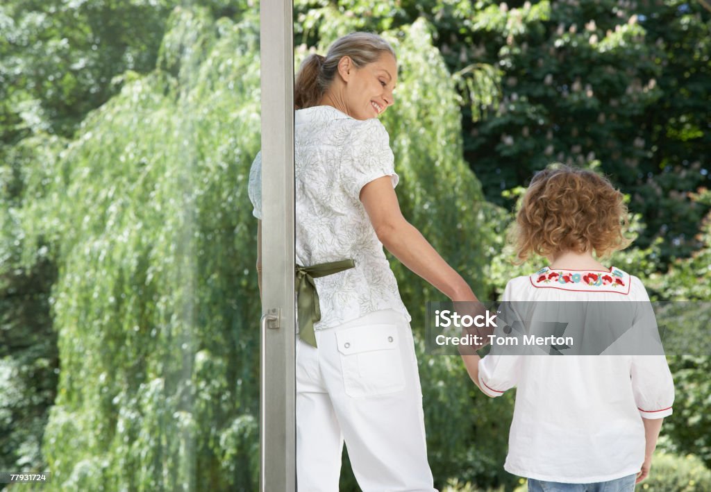 Frau und junge Mädchen, stehend vor einem großen Glas Tür - Lizenzfrei Hausgarten Stock-Foto