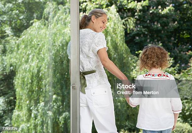 Frau Und Junge Mädchen Stehend Vor Einem Großen Glas Tür Stockfoto und mehr Bilder von Hausgarten