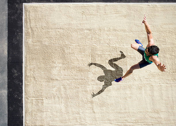 Athlete doing a long jump into a sandpit  long jump stock pictures, royalty-free photos & images