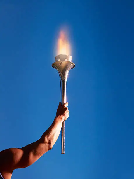 Photo of Athlete's arm holding up a torch
