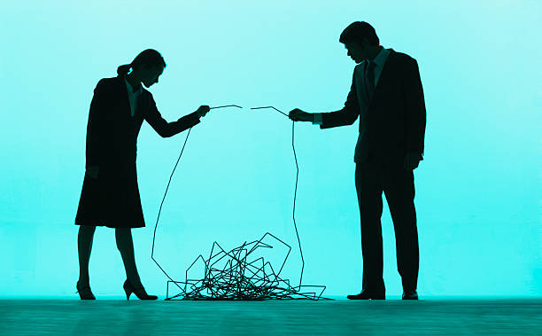 Two businesspeople holding ends of a cable and putting them together  bound woman stock pictures, royalty-free photos & images