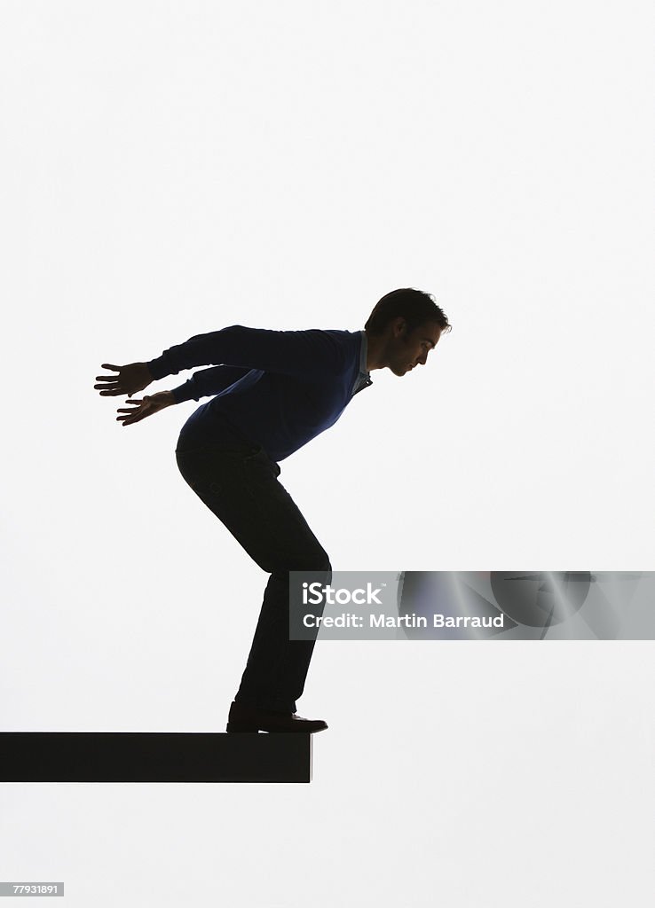 Uomo in piedi su una tavola di legno su per saltare su ripiano - Foto stock royalty-free di Ambientazione interna