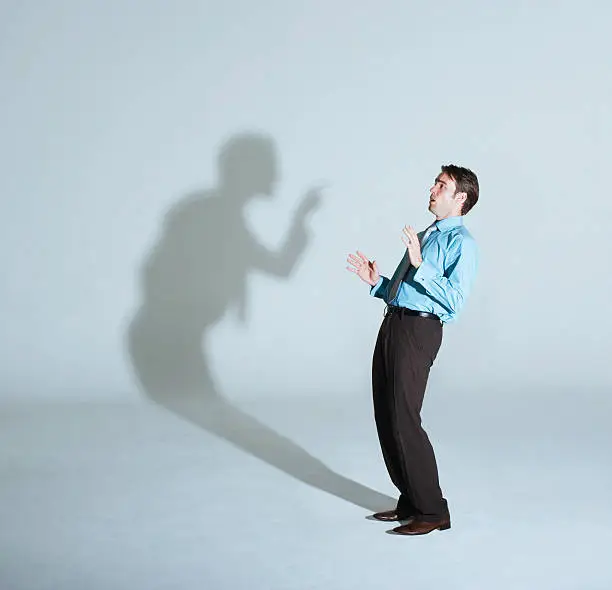 Photo of Businessman being scolded by his shadow