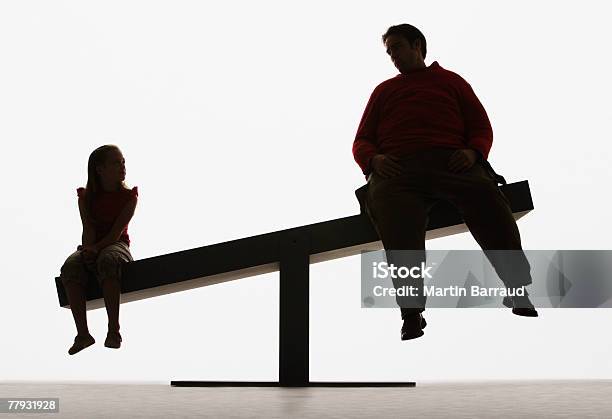 Große Mann Und Kleine Mädchen Auf Unausgewogen Plank Stockfoto und mehr Bilder von Gegensatz