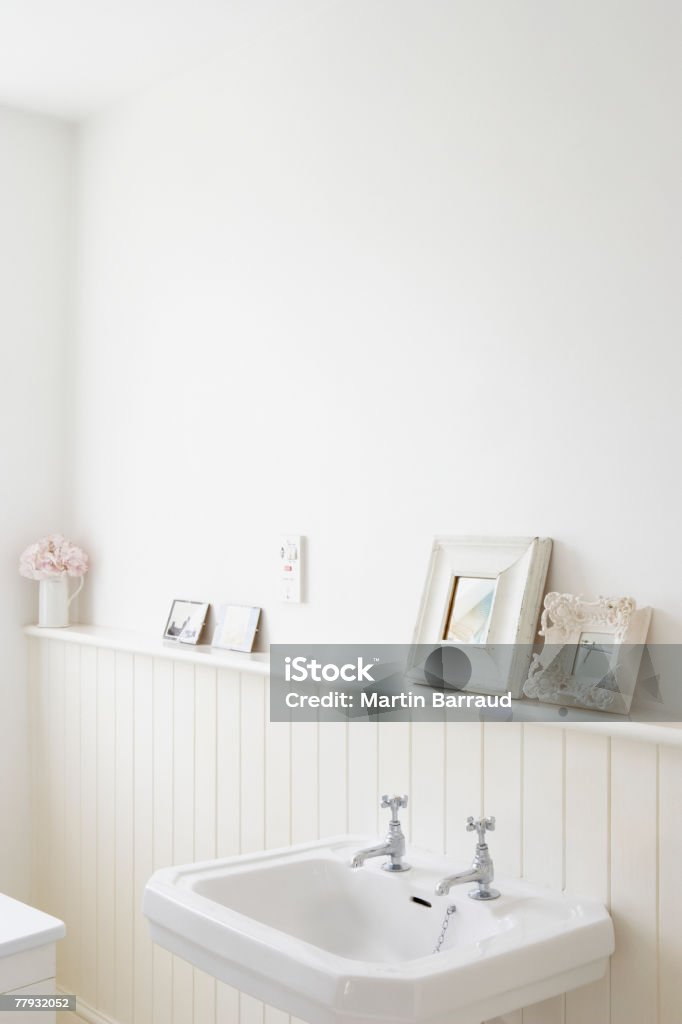 Vide salle de bains avec des photos sur une étagère - Photo de Lavabo libre de droits