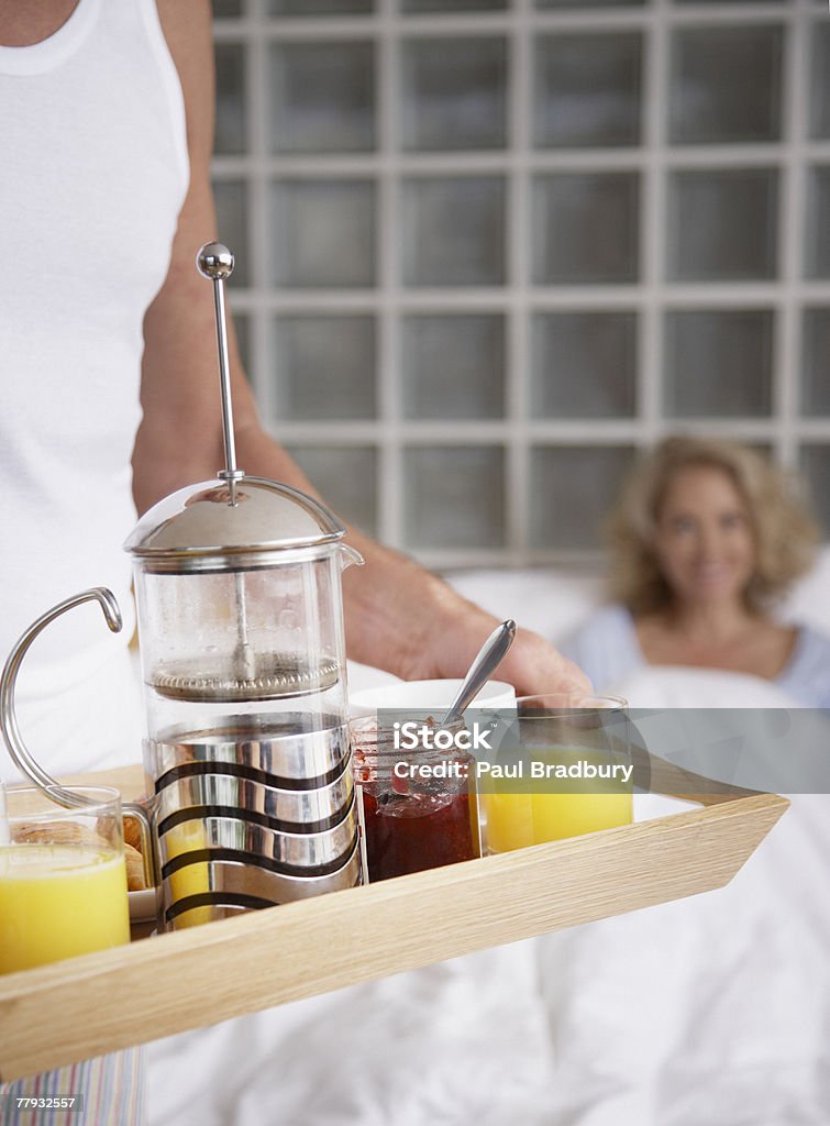 Donna uomo portando la colazione a letto - Foto stock royalty-free di 50-54 anni