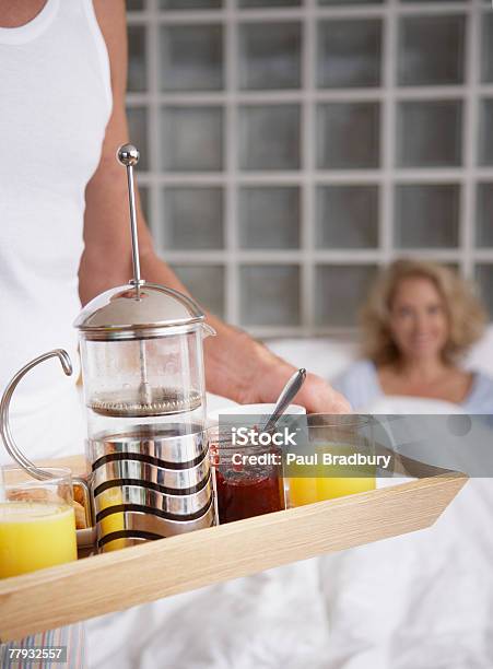 Kobieta Mężczyzna Przynosząc Śniadanie W Łóżku - zdjęcia stockowe i więcej obrazów 50-54 lata - 50-54 lata, 55-59 lat, Beztroski