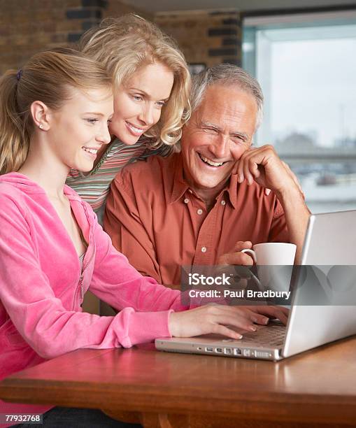 Foto de Casal Com Garota Com O Laptop Em Casa Moderna e mais fotos de stock de 14-15 Anos - 14-15 Anos, 50-54 anos, 55-59 anos