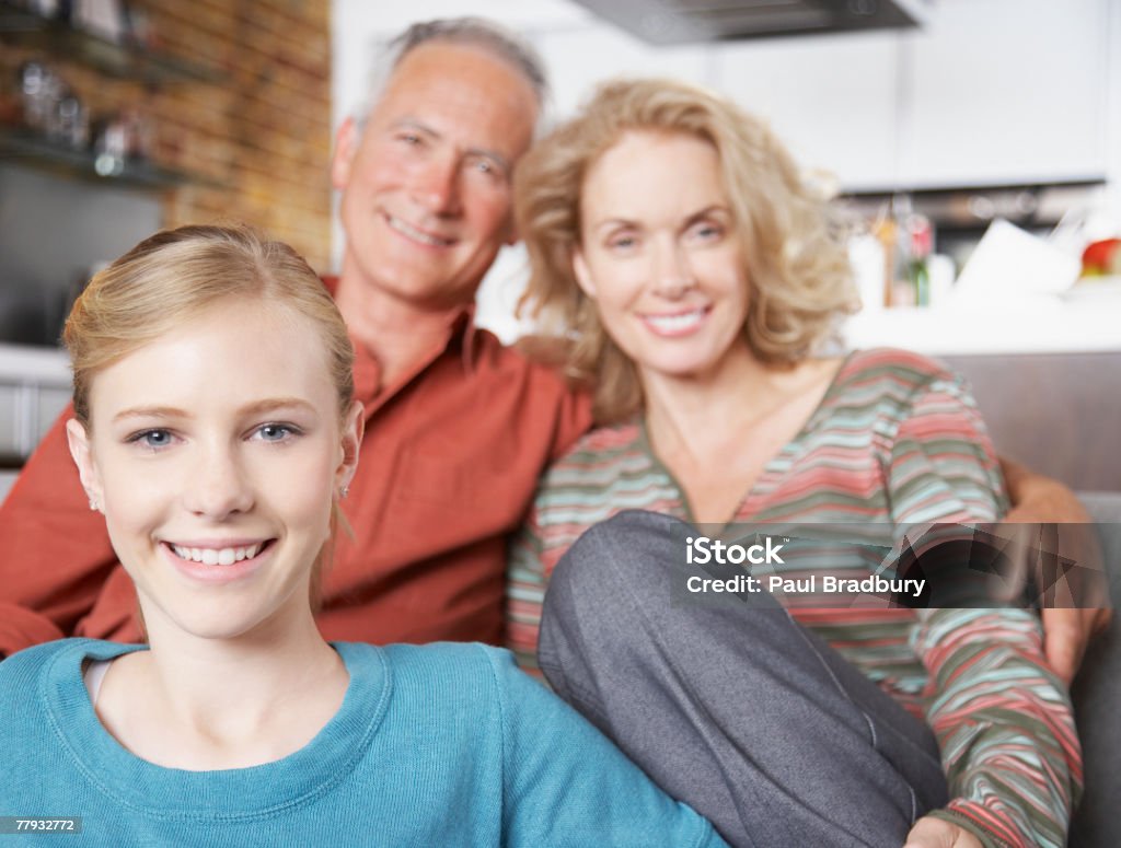 Casal e uma menina sentada na sala de estar - Foto de stock de 50-54 anos royalty-free