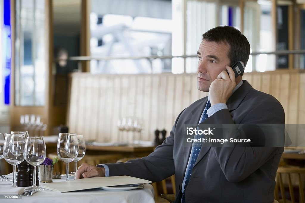 Uomo d'affari sul cellulare in ristorante - Foto stock royalty-free di Adulto