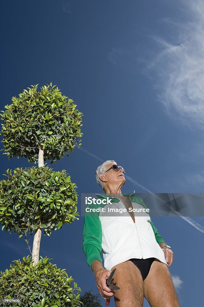 Uomo anziano in giardino - Foto stock royalty-free di Uomini