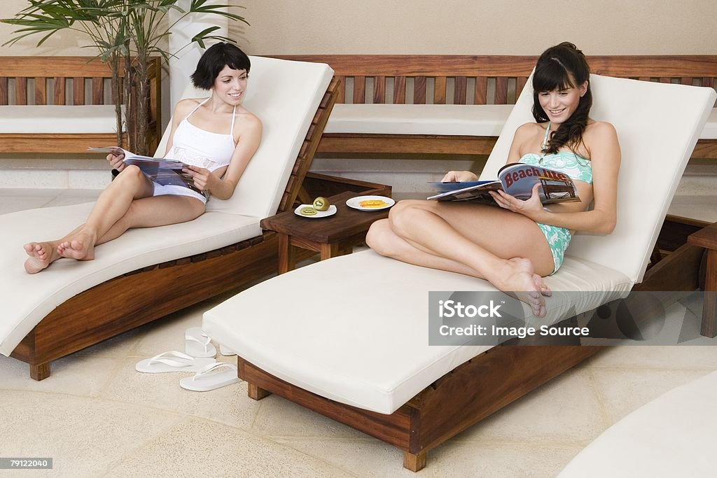 Женщин на стулья и журналы - Стоковые фото Баловство роялти-фри