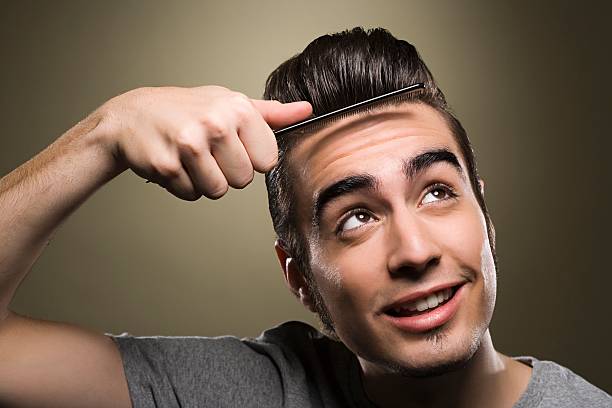 Young man combing his quiff  rockabilly hair men stock pictures, royalty-free photos & images