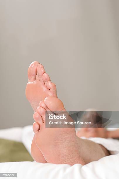 Foto de Homem Sênior Com Seus Pés e mais fotos de stock de Adulto - Adulto, Cabelo Grisalho, Cama