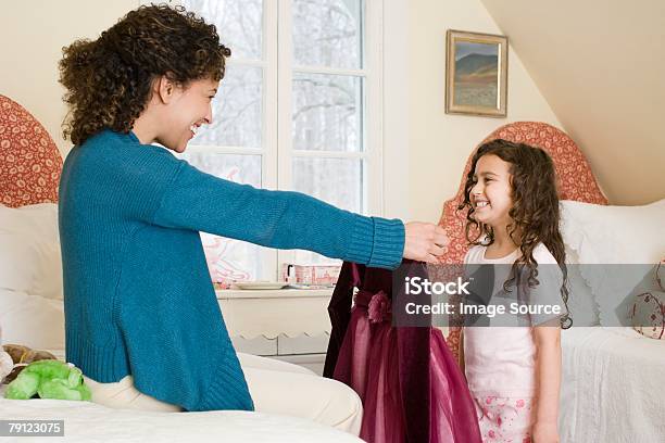 Mother Giving Dress To Daughter Stock Photo - Download Image Now - Daughter, Dress, Giving