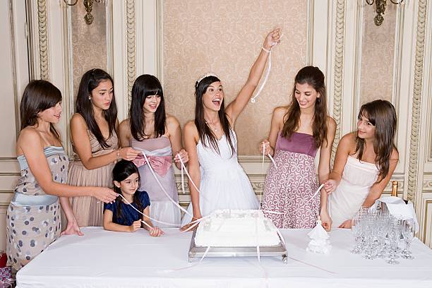 Girls pulling ribbons from cake  quinceanera stock pictures, royalty-free photos & images