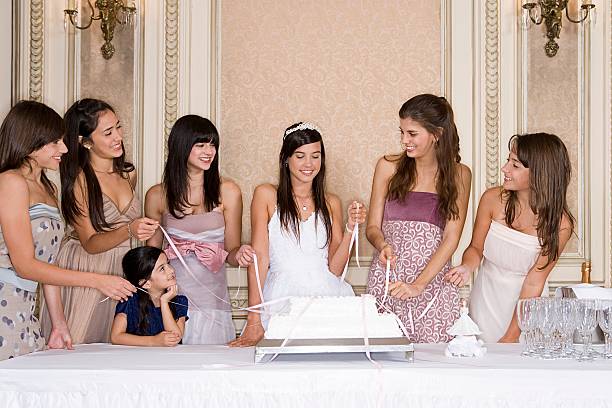 Girls pulling ribbons from cake  quinceanera stock pictures, royalty-free photos & images