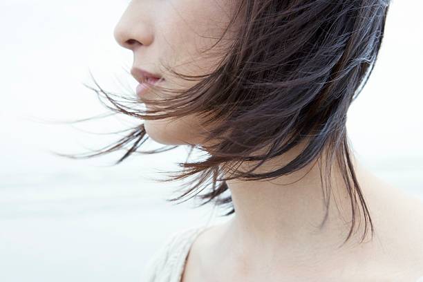 femme avec les cheveux dans le vent souffle - cheveux dans le vent photos et images de collection